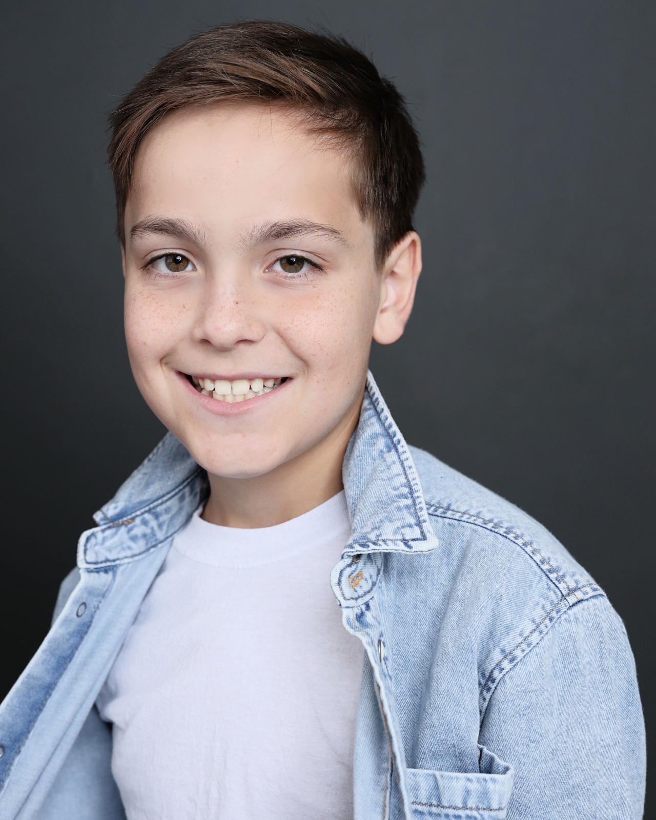 Jett Belew headshot, smiling, denim shirt